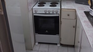 A compact kitchen with a white stove, oven, and a microwave. - Vacation and Relaxation  (Montego Bay)