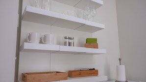 A kitchen with white shelves holding mugs, glasses, and containers. - Quiet Relaxation Retreat Near Bondi Beach, The Cute Place To Put Up Your Feet (North Bondi)