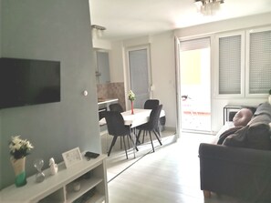 Relax in a stylish living space with a flat-screen TV, dining area, and comfortable seating.