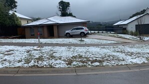 A residential area with a house featuring a garage and a parked car. - Marysville Views - Peaceful Snow Escape | Spacious 4BR Retreat (Marysville)