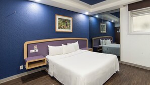 A hotel room with a large bed, a nightstand, a mirror, and a framed picture on the wall. - Hotel Menara (Mexico City)