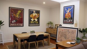 A dining area with a wooden table and chairs, a map on the wall, and posters of Porto Pitter's and Rita's. - Amazing location - Walk to MCG/Swan St/Bridge Rd/Melbourne CBD (Richmond)