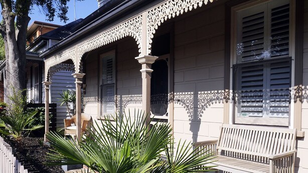 A porch with a bench, surrounded by a white picket fence and tropical plants. - Amazing location - Walk to MCG/Swan St/Bridge Rd/Melbourne CBD (Richmond)