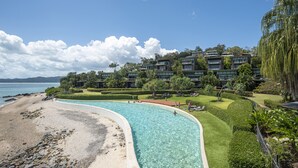 Ein Resort mit Schwimmbad, Strand und üppiger Bepflanzung.