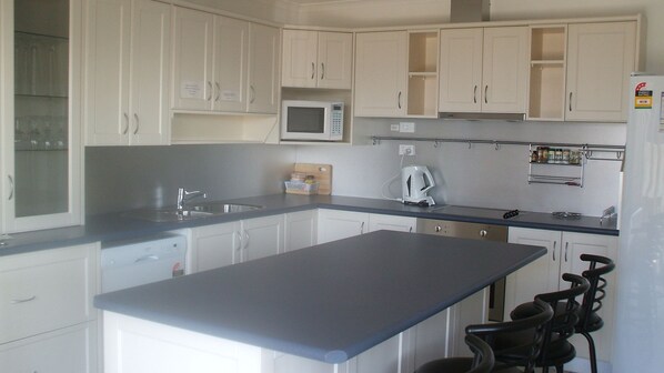 Compact kitchen with central island, sink, and microwave, perfect for preparing meals.