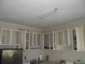 Kitchen features white cabinetry and a stainless steel refrigerator with ample counter space.