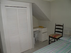 Cozy retreat with a single bed, desk, and wardrobe.