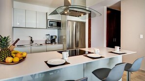 A modern kitchen with a central island, stainless steel appliances, and a glass ceiling. - *LUXURIOUS* One Bedroom Condo behind Mamitas Beach (Gonzalo Guerrero)