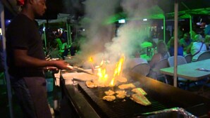 A person grilling food on a barbecue at an outdoor event. - Vacation rental near Dover Beach and St. Lawrence Gap (Christ Church)