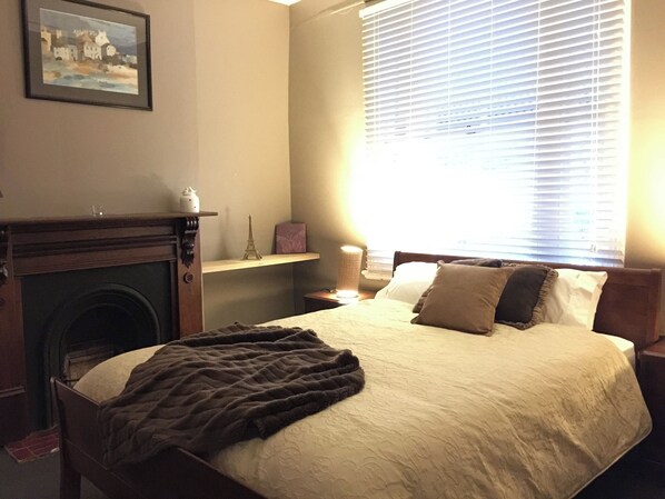 A bedroom with a bed, a fireplace, a window with blinds, and a painting on the wall. - Perfect Location for Leisure or Business - Right in the main street (Scone)