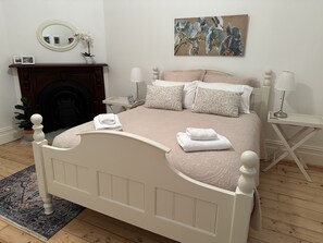 A neatly arranged bedroom with a bed, bedside tables, a fireplace, and a painting on the wall. - AAA Yapera on Lucan.  Central Bendigo house, Close to all Bendigo venues (North Bendigo)