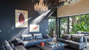 A modern living room with a large sofa set, a coffee table, and a Buddha statue by the window. - Villa Yang-5 BR Luxury Villa(Butler,Chef,Transfer) (Kamala)
