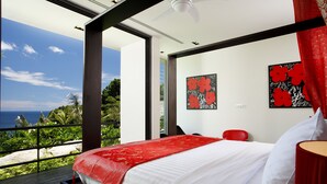 A modern bedroom with a large bed, a red throw blanket, and artwork on the walls. - Villa Yang-5 BR Luxury Villa(Butler,Chef,Transfer) (Kamala)