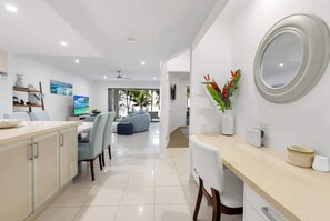 A modern kitchen with a dining area, a large mirror, and a view of the outdoors.