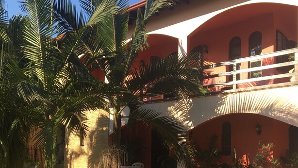 A building with a red facade, a balcony, and a satellite dish. - Vacation home 4 Palmeiras  (Figueira)