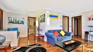 A modern living room with a blue sofa, a coffee table, and a globe on a side table.