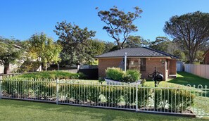 A beach house with a fenced yard and a small patio area.