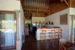 Cozy kitchen with a central island, sink, and wooden ceiling with exposed beams.