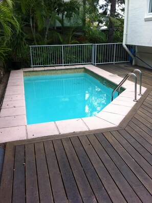 Relax by the pool surrounded by lush greenery and tropical plants.