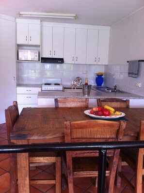 Enjoy meals in this kitchen with stove, dining table, and comfortable seating.