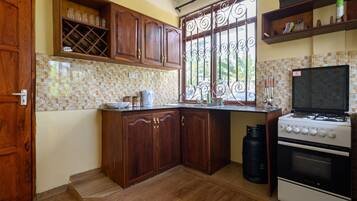 Een koelkast, een oven, kookgerei, borden en bestek