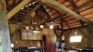 Une cuisine rustique avec des meubles de rangement en bois, une grande cuisinière et une table à manger en bois.