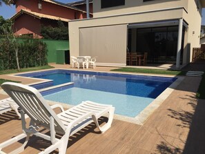 Relax by the pool surrounded by a deck and a low fence, with lounge chairs for ultimate relaxation.