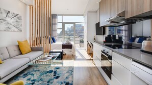 A modern apartment with a kitchen, living area, and large windows offering a city view. - Backup-Powered City Apartment with Breathtaking Views on Popular Bree Street  (Cape Town)
