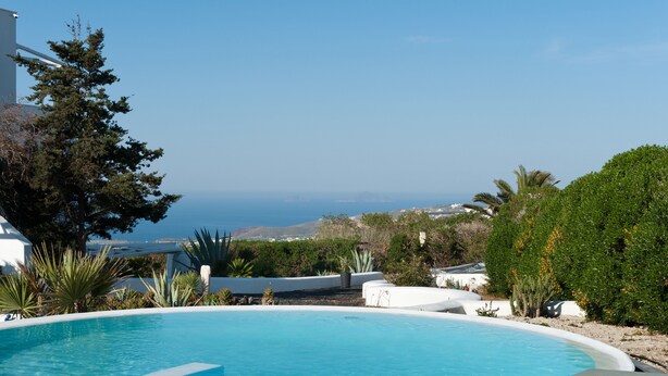 Una piscina con vistas al mar y colinas.