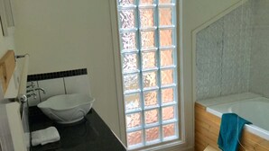 A bathroom with a sink, a window, and a bathtub.