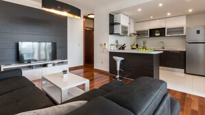 Een moderne woonkamer met een flatscreen televisie, een bank en een salontafel.