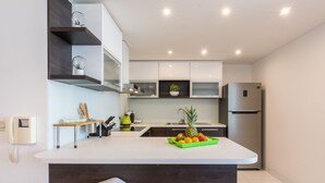 Een moderne keuken met een centraal eiland, ingebouwde apparatuur en een minimalistisch ontwerp.