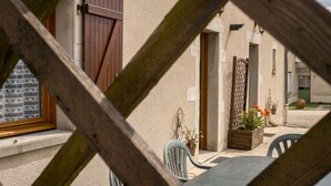 A patio area with a table and chairs, a wooden gate, and potted plants. - Countryside house - Le Rochepot - Cote d'Or (La Rochepot)