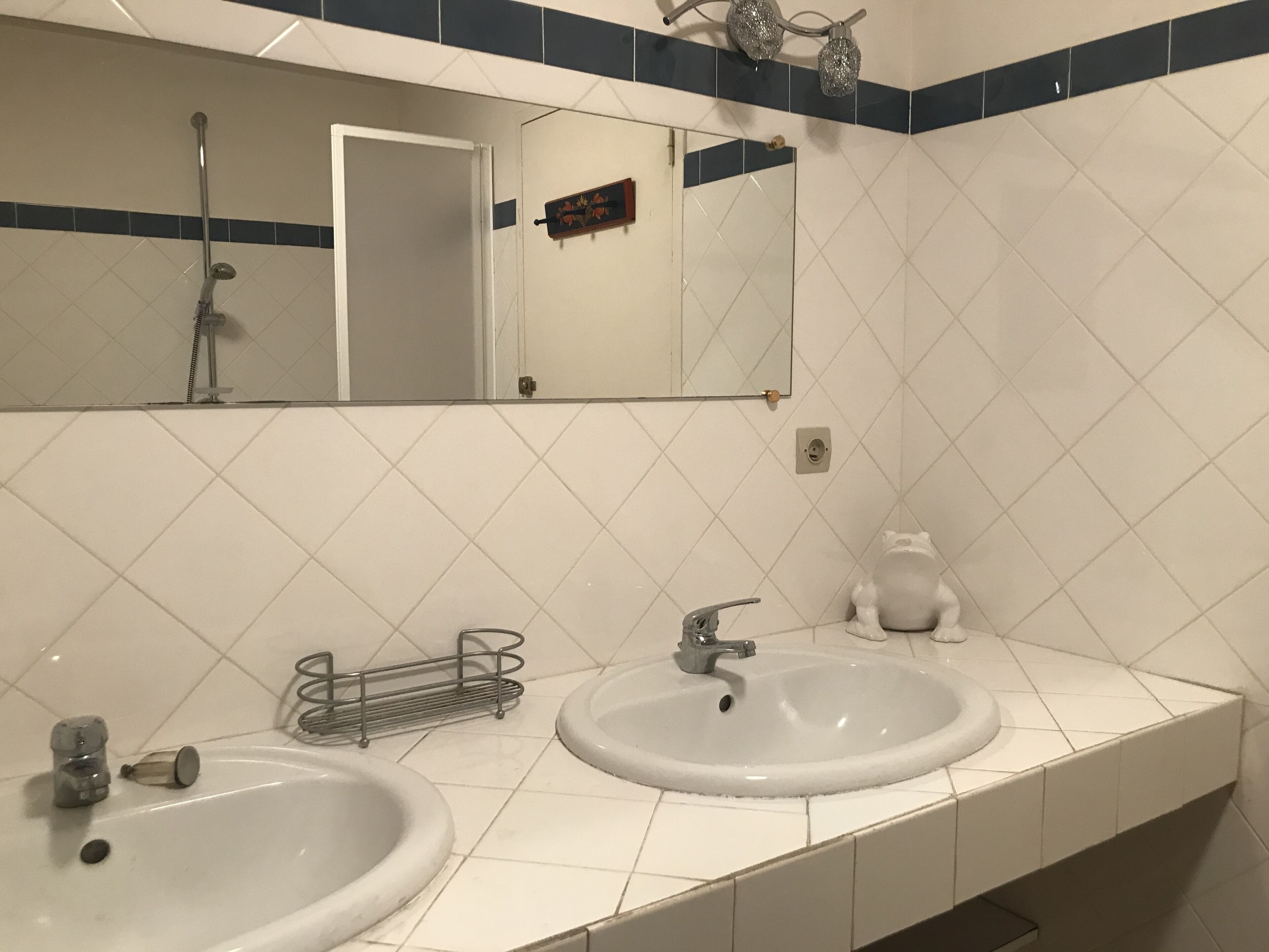 Un baño con dos lavamanos, un espejo y una ducha.