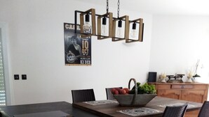 A modern kitchen with a large island, dark cabinetry, and a hanging light fixture. - Furnished one-storey villa with 8 sleepings with a private pool (Bias)