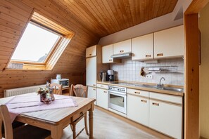 Eine gemütliche Küche mit Holdekor-Schränken, einem eingebauten Backofen und einem Fenster über der Spüle.