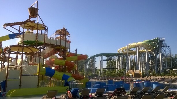 A water park with a large pool, a water slide, and a wave pool.