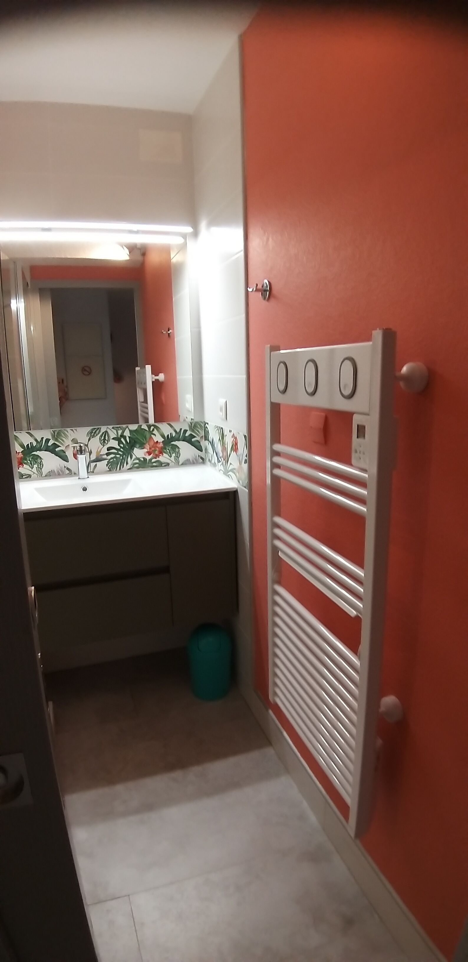 A bathroom with a white sink, mirror, and a towel rack.