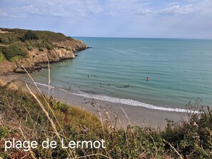A coastal landscape with a beach and cliffs.
