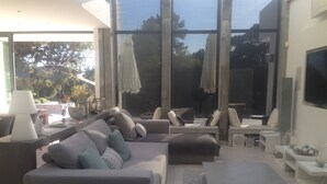 Un saló modern amb un sofà gris, una taula de centre i un televisor penjat a la paret.