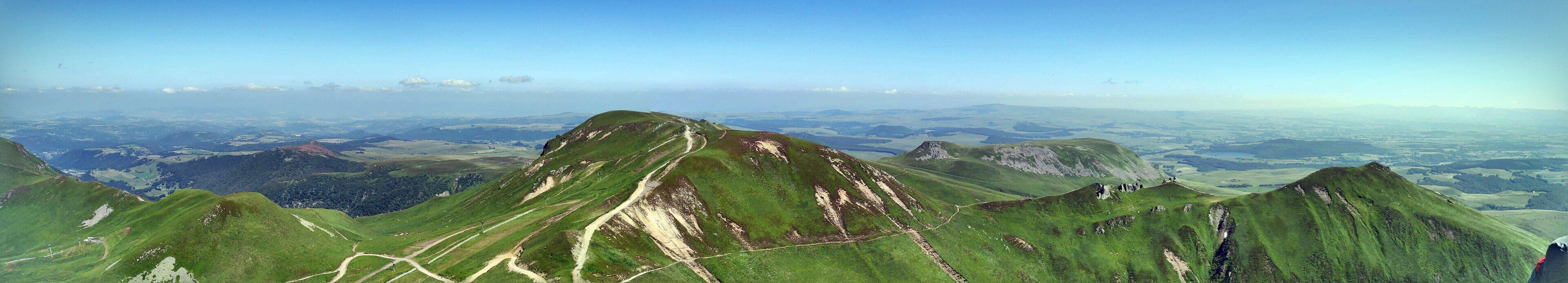 Een bergachtig landschap met kronkelende paden en een helder uitzicht over de vallei.