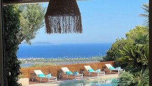 A poolside area with wicker furniture, a hanging light fixture, and a view of the sea. - High end estate with superb sea view, heated swimming pool, tennis, jacuzzi (Hyères)
