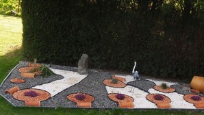 A garden with a gravel path, circular flower beds, and a large tree. - Former manor house, quiet estate, south courtyard and peaceful atmosphere (Evran)