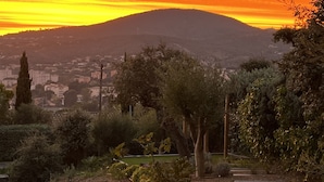 Ein Sonnenuntergang mit einem Berg im Hintergrund und einem Garten mit einem Kiesweg.