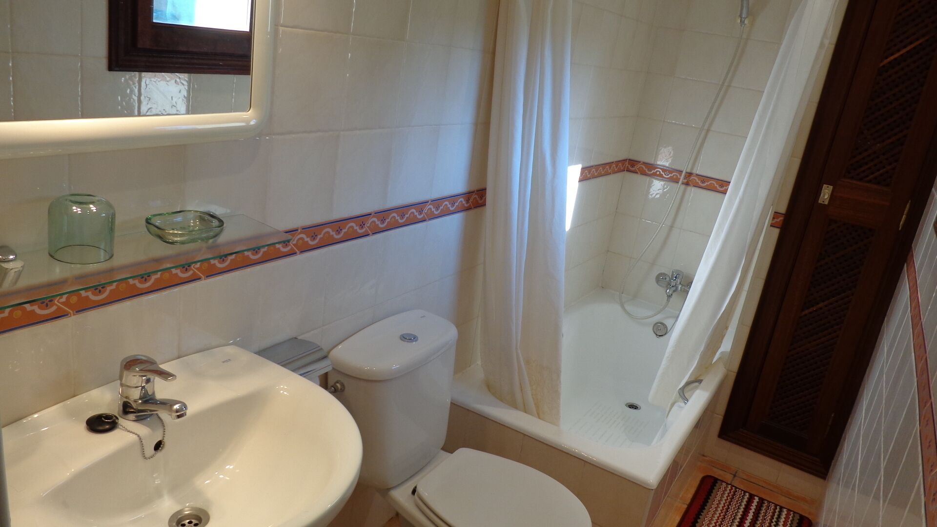 Een badkamer met een wastafel, toilet en douche.
