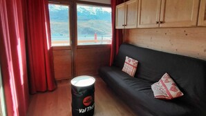 Huoneessa on musta sohva, punaiset verhot, puukaapit ja rumpu, jonka kylkeen on kirjoitettu teksti ”Val Thor”.