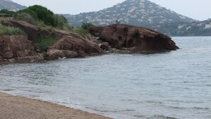 A rocky shoreline with a bench overlooking calm water.