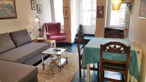 A cozy living room with a sofa, a chair, a table with a green tablecloth, and a bookshelf. - Apartment in the Heart of the City 4 (Istanbul)