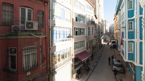 A narrow street lined with multi-story buildings, featuring balconies and ground-floor shops. - Apartment in the Heart of the City 4 (Istanbul)