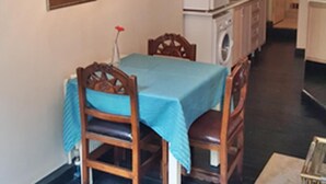 A small kitchen with a dining table, chairs, a refrigerator, and a washing machine. - Apartment in the Heart of the City 4 (Istanbul)